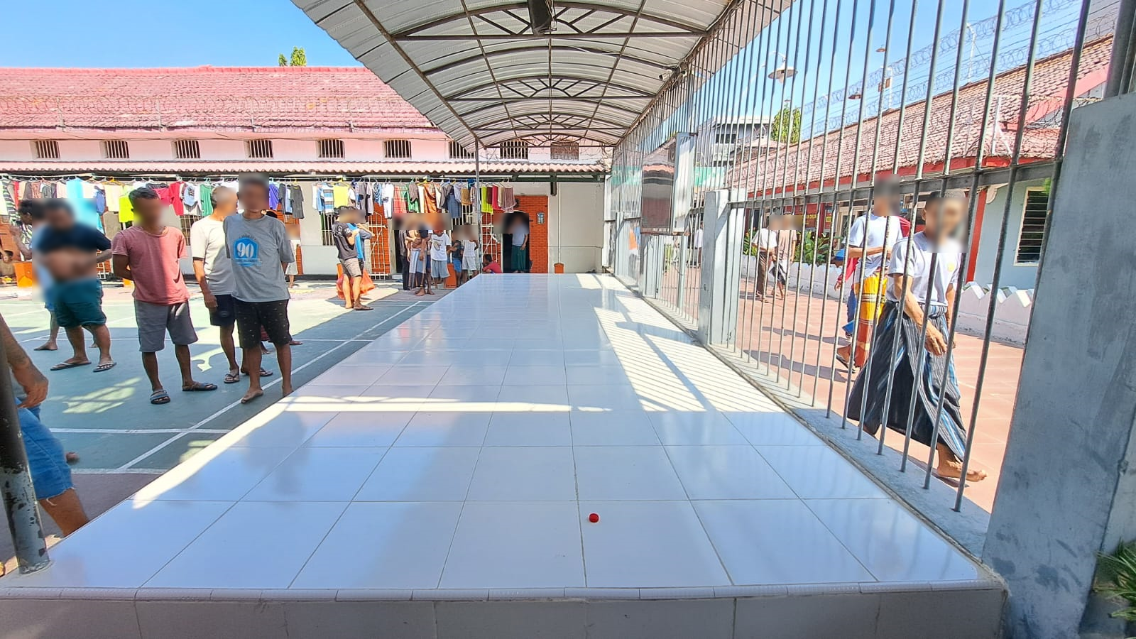 Recreational yard at Mojokerto Class IIB Correctional Facility, showing inmates in a communal area.