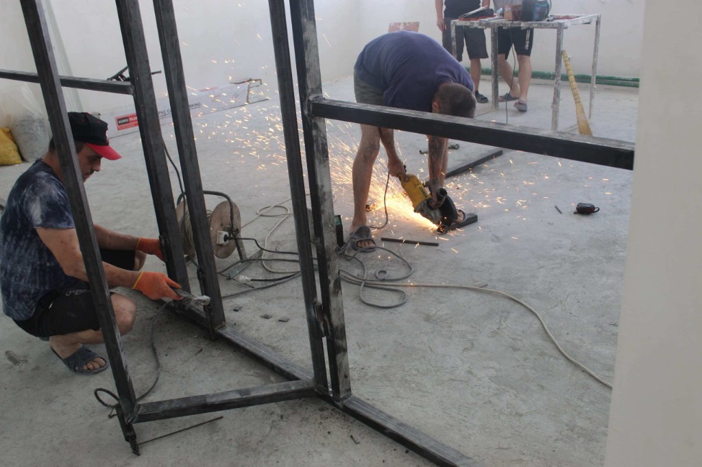 Prisoners welding and assembling metal frames for the gymnasium renovation