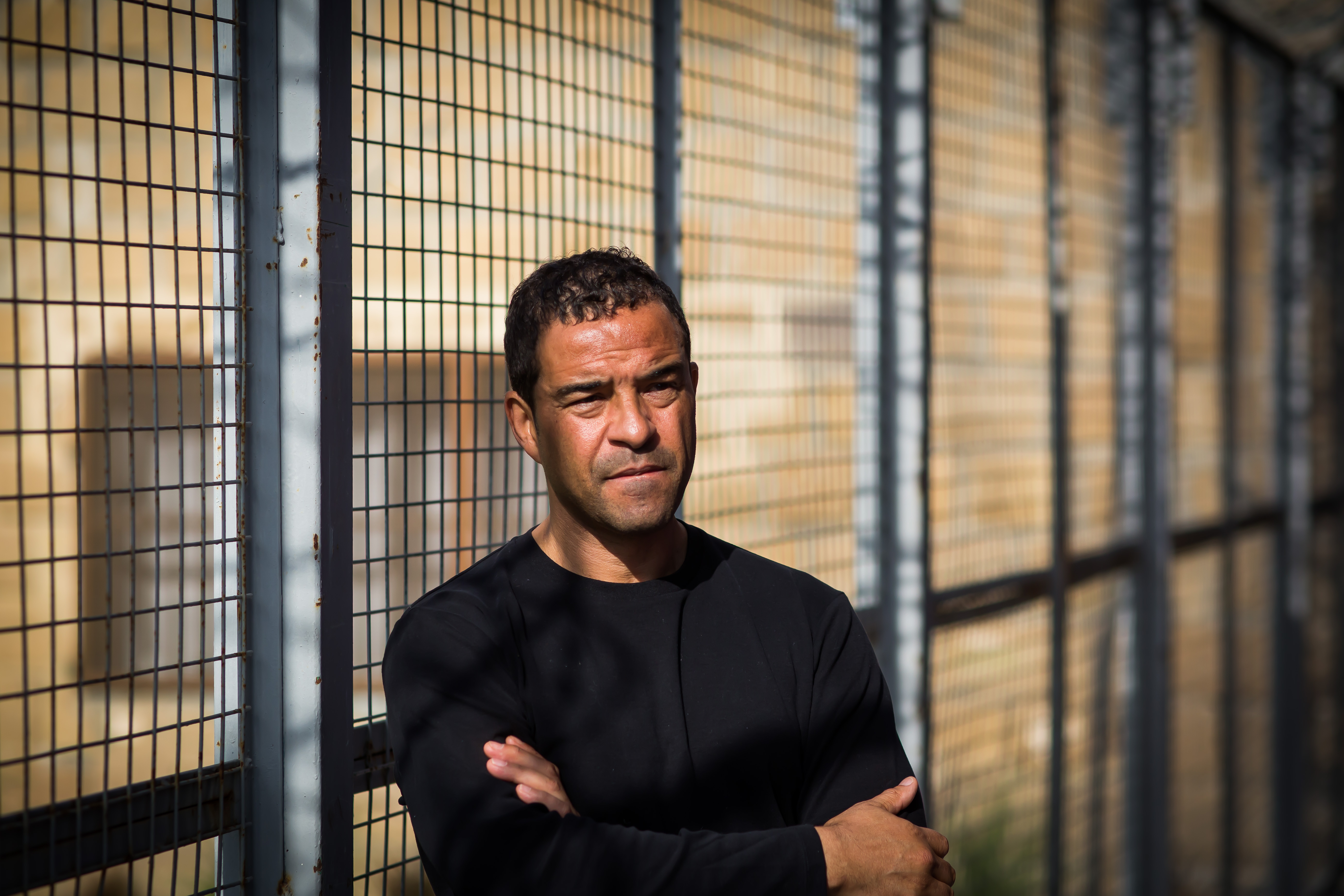 Raphael Rowe portrait against prison bars