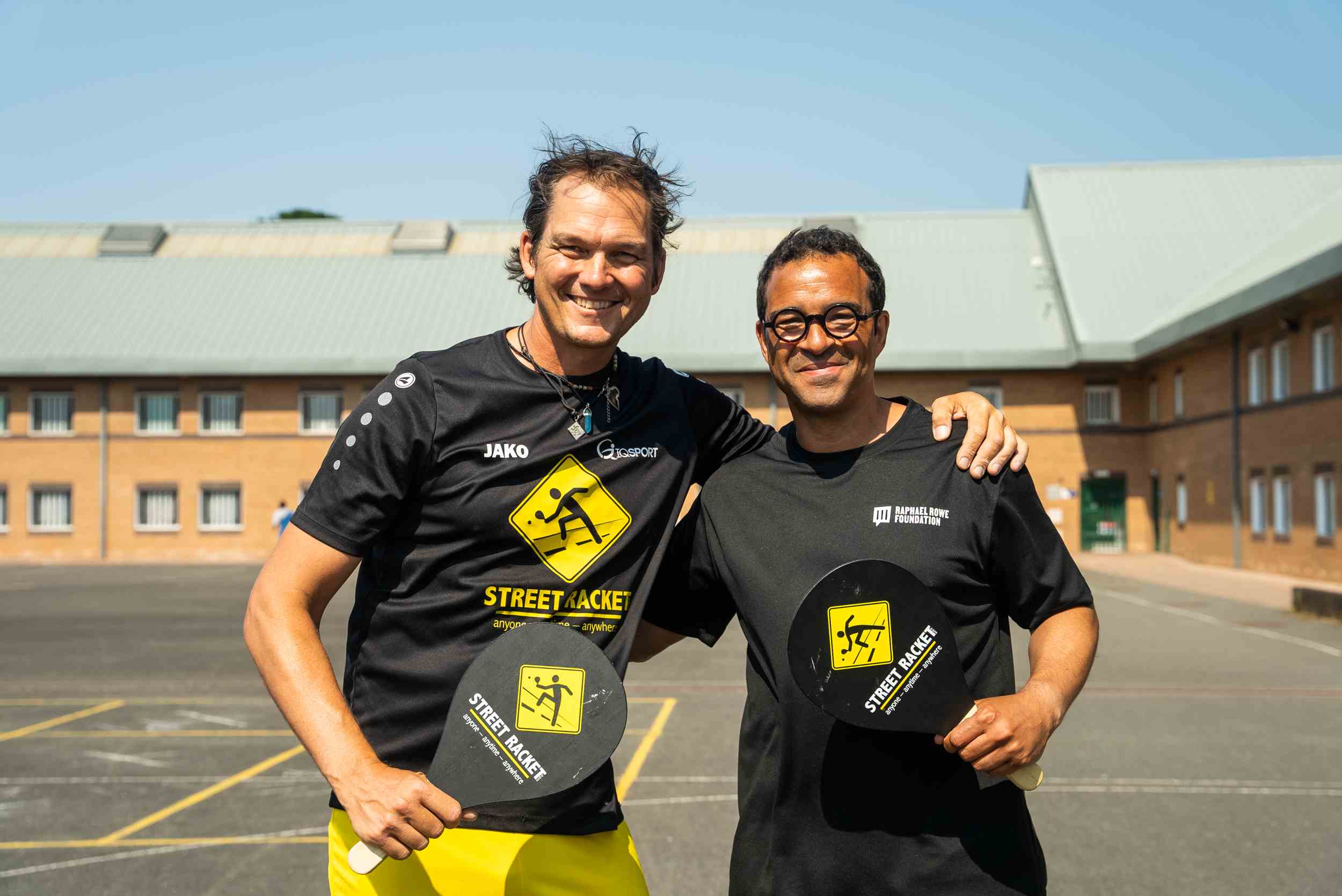 Street Racket founder and Raphael Rowe holding rackets in prison yard